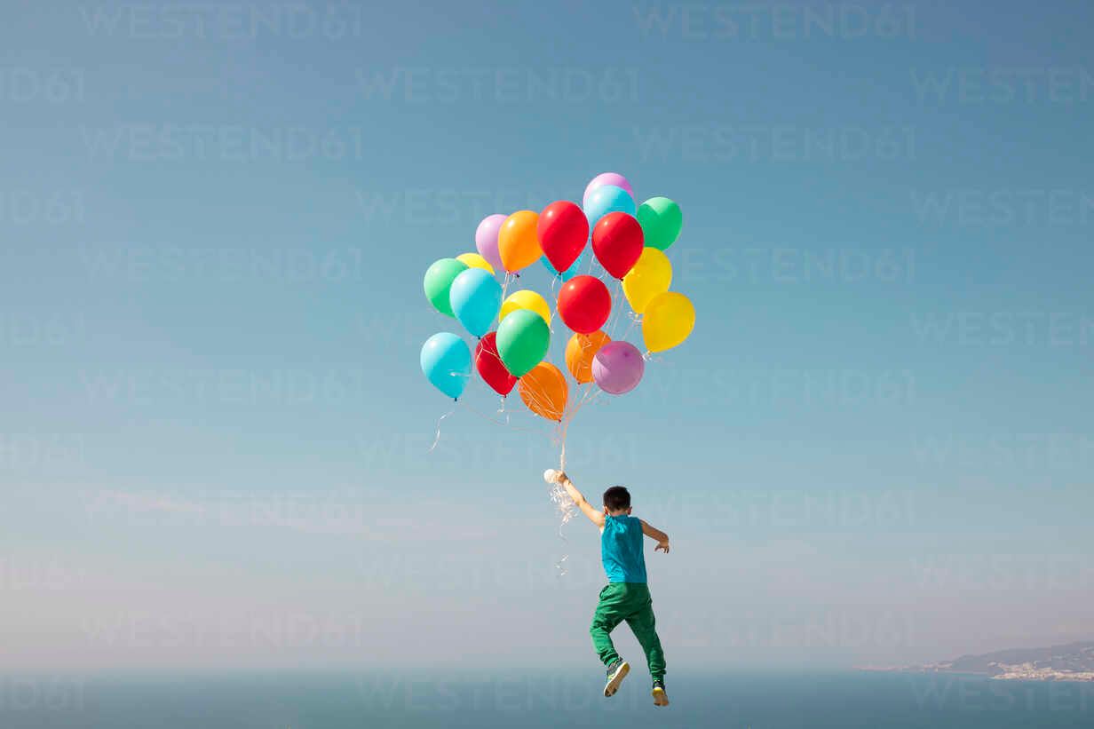 boy-flying-with-bunch-of-balloons-in-sky-LJF02159.jpg